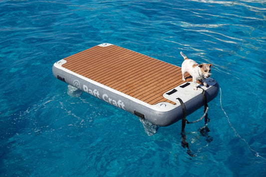 Raft Craft RC101 floating dock on open water, teak-effect deck and Raft Craft wordmark on the side tube