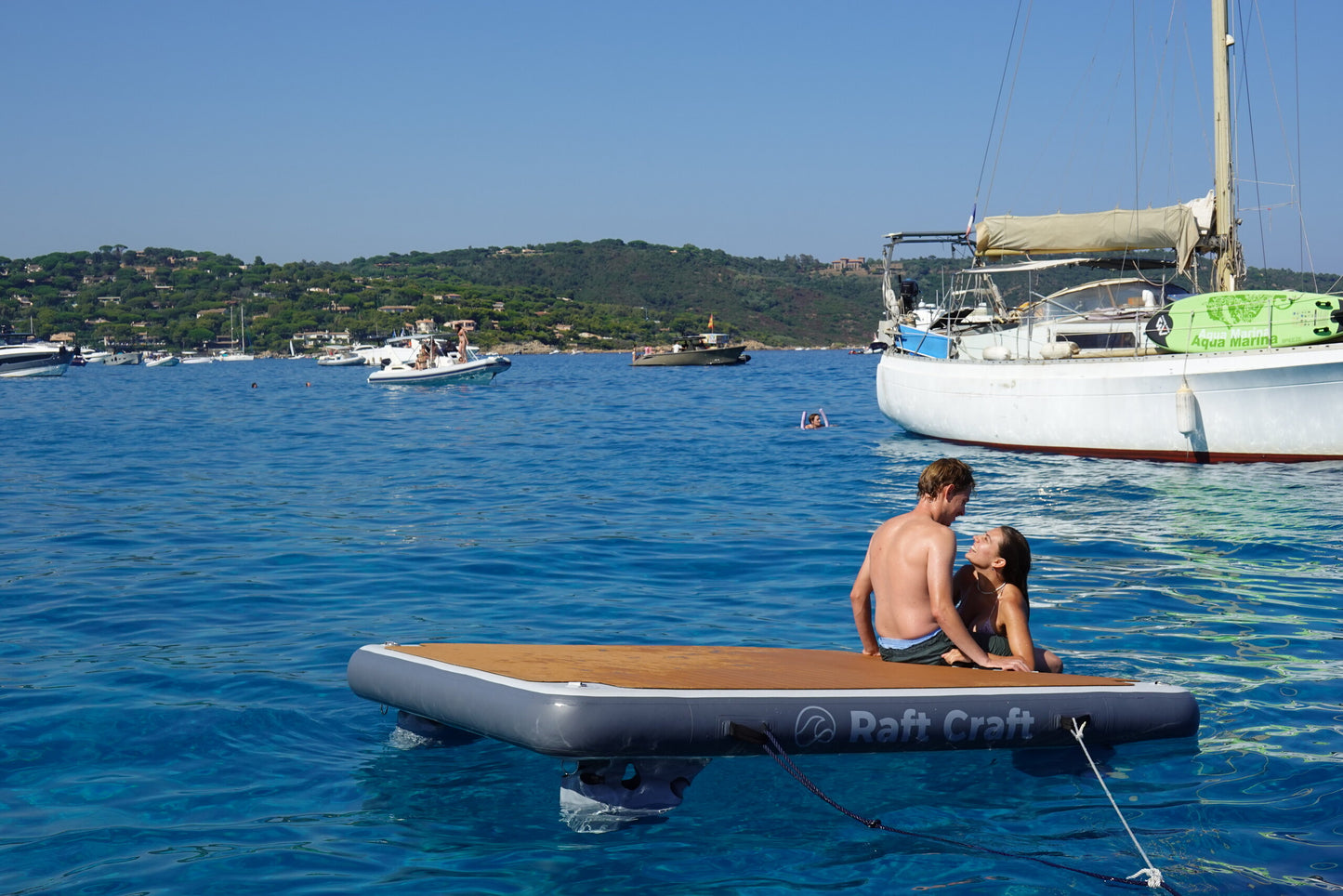 RC102 floating dock set up with a cushion and side table on calm water