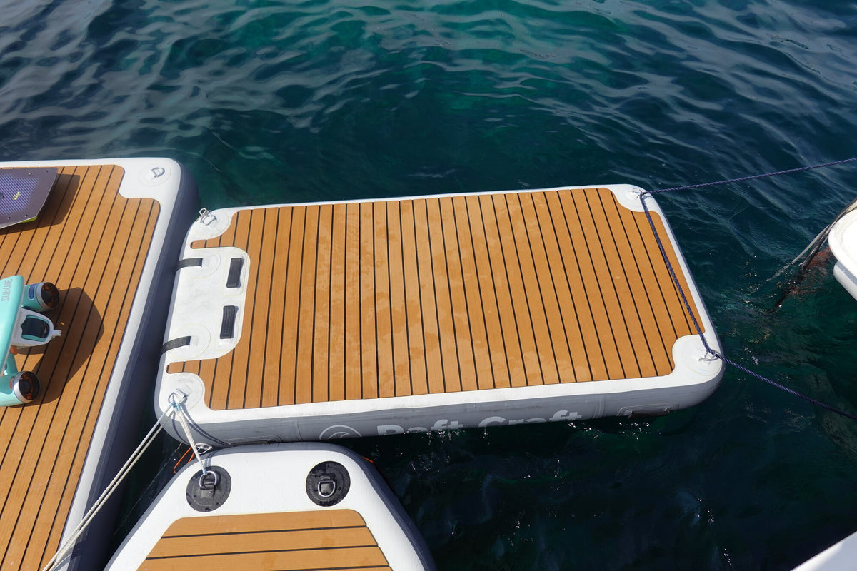 Close-up of the teak-effect EVA deck, stainless D-rings and moulded carry handles on a Raft Craft dock